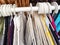 Hangers with a variety of clothes on a white rack. Home storage of clothes. Clutter. Littery. Declutter. Garage sale