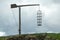 Hanging cage surrounded by greenery under a cloudy sky in France