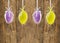 Hanging Easter eggs, background of wooden wall
