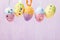 Hanging Easter eggs decorated in various colors. Festive background with copy space