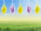 Hanging Easter eggs on spring field background