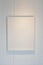 Hanging empty wooden picture frame on orderly dot or hole wall with orange light form ceiling