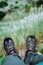 Hanging feet with trekking footwear over hill with sugarcane plants. Santo Antao Island, Cape Verde