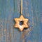 Hanging gingerbread or cookies star on wooden background for christmas