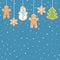 Hanging gingerbread man, tree, snowman and stars cookies on blue