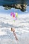 Hanging girl to a group of balloons flying toward a world upside