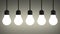 Hanging glowing tungsten light bulbs on gray