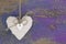 Hanging heart and purple wooden background in country style.