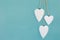 Hanging hearts and turquoise background in country style. Chic, card.