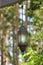 Hanging lamp on a track in front of a forest of metal and glass. Illuminated