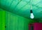 Hanging modern light bulb with green wooden planks