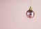 Hanging pink baubles with gitters on pink background.