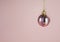 Hanging pink baubles with gitters on pink background.