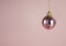 Hanging pink baubles with gitters on pink background.