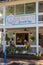 Hanging plants, a cozy porch, and colorful signage at a beach-themed restaurant in Dahlonega, Georgia