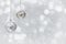 Hanging silver christmas balls covered snow on a blur light background with space for text