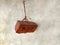 Hanging single brick tie with rope and wall background