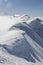 Hanging snow cornices on the mountain ridge