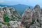 Hanging suspension bridge over abyss in steep rocks Ai-Petri, Crimea. Cliff against the backdrop of blue mountains with forest