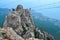 Hanging suspension bridge over an abyss in steep rocks with going man. Ai-Petri, Crimea. Against the backdrop of the Black Sea