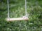 Hanging swings on a background of green grass with flying almonds