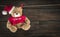 Hanging teddy bear in a christmas hat on a wooden background