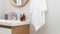 Hanging towel, sink, burning candles and toiletries in bathroom. Interior design