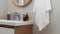 Hanging towel, sink, burning candles and toiletries in bathroom. Interior design