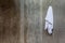 Hanging white towel draped on exposed concrete wall in the bathroom.