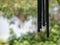 Hanging wind chimes hanging in a backyard on a sunny day