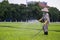 HANOI, VIETNAM - CIRCA AUGUST 2015: Worker water grass outside Ho Chi Minh mausoleum in Hanoi