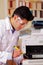 Hansdome man fixing a photocopier during maintenance using a screwdriver wearing work glasses