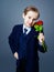 Hansome boy wearing a black suit with roses in his hands