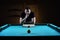 Hansome man playing billiards alone
