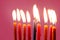 Hanukkah burning candles on the pink background