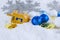 Hanukkah decorations including gelt, sparkly ornaments and a dreidel in snow.