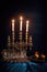 hanukkah menorah with candles lit against dark backdrop