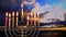 Hanukkah menorah with candles, sunset sky background