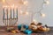 Hanukkah Menorah celebration of candles decorated with gifts and lights on a wooden table