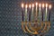 Hanukkah Menorah Lit Candles with blue fabric pattern background