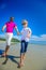 The happiest childhood: father and son running along the tropical beach