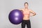 Happines woman holding aerobic ball and pointing finger on him