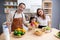 Happiness asian family with father, mother and daughter preparing cooking salad vegetable food together in kitchen.