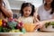 Happiness asian family with father, mother and daughter preparing cooking salad vegetable food together in kitchen.