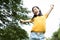 Happiness asian woman standing feel comfortable at park,smiling female teenage with stretching her arms,enjoy breathing fresh air,