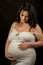 Happiness Beautiful pregnant brunette in light clothes showing s