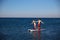 Happiness boy and girl holding hands on sup surf swimming at the ocean. Concept lifestyle, sport, love