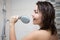 Happiness concept - portrait of young woman singing in shower