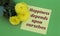 HAPPINESS DEPENDS UPON OURSELVES - words on a sheet of paper with yellow flowers on a green background