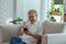 Happiness elderly asian man sitting on sofa and using mobile phone VDO Conference online meeting with family and smile at home,